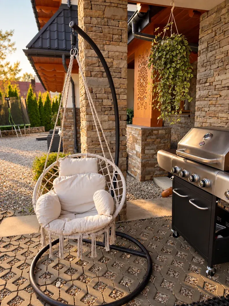 Wiszący fotel i grill gazowy przy wejściu